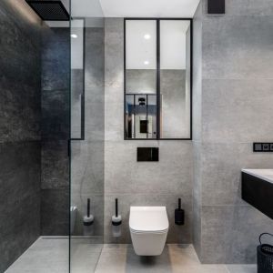 Wygodna łazienka z prysznicem urządzona w szarościach z dodatkiem czerni. Projekt: Małgorzata Staniek, pracownia Marbou. Fot. Karol Kleszyk, Promo Focus
