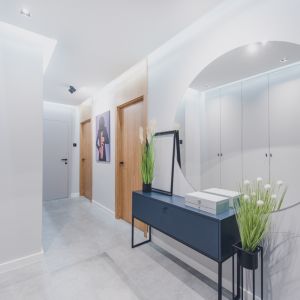 Jasny przedpokój i dużym, okrągłym lustrem. Projekt: Iwona Jałocha, Jałocha Design, Dekorian Home. Fot. Wojciech Mateusiak