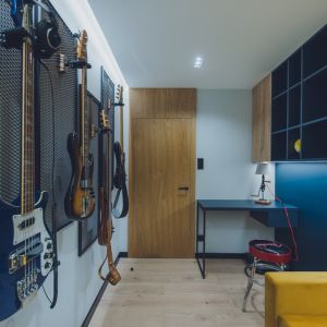 W gabinecie uwagę zwracają pięknie wyeksponowane na ścianach gitary basowe. Projekt: Iwona Jałocha, Jałocha Design, Dekorian Home. Fot. Wojciech Mateusiak