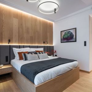 Ścianę za łóżkiem w nowoczesne sypialni pięknie zdobi naturalny forniru dębowy. Projekt i zdjęcie: KODO Projekty i Realizacje Wnętrz