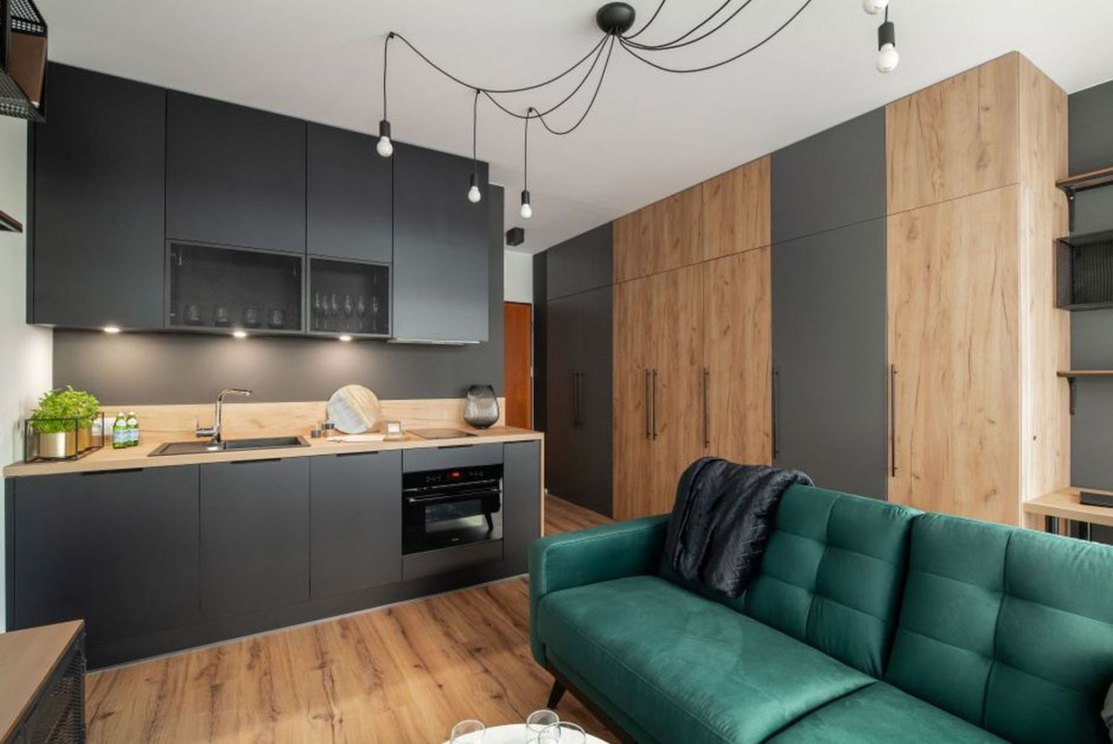 Czarna kuchnia w mieszkaniu o powierzchni 26 m2 na Żoliborzu. Projekt i zdjęcie: KODO Projekty i Realizacje Wnętrz