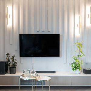 Ściana za telewizorem w salonie z pionowymi listwami dekoracyjnymi. Projekt i zdjęcia: KODO Projekty i Realizacje Wnętrz