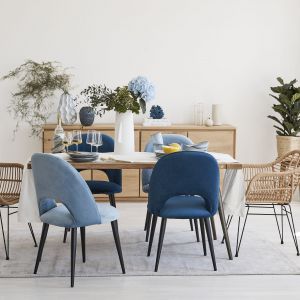 Jadalnia w stylu Hamptons - niebieski i rattanowe krzesła, dużo drewna i bieli. Fot. mat. prasowe WestwingNow