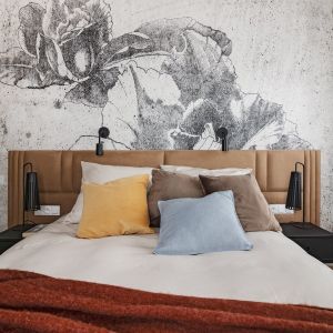 Ścianę za łóżkiem w sypialni zdobi tapeta w kwiatowym wzorem. Projekt: Klaudia Tworo Architektura Wnętrz. Fot. Kamila Markiewicz-Lubańska