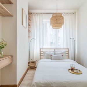 Mała sypialnia w bloku urządzono została w bieli i z dużą ilością drewna. Projekt i stylizacja wnętrza: Ola Dąbrówka, pracownia Good Vibes Interiors. Fot. Marcin Mularczyk