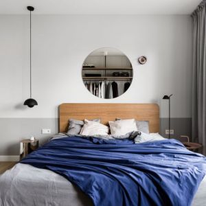 Sypialnia w jasnych kolorach i z drewnianym łóżkiem. Projekt: Raca Architekci. Fot. Fotomohito