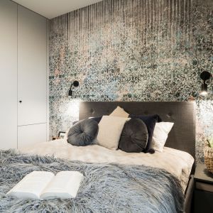 W sypialni poza dużym komfortowym łóżkiem z tapicerowanym wezgłowiem w kolorze szarym mamy też szafę. Projekt i zdjęcia: KODO Projekty i Realizacje Wnętrz
