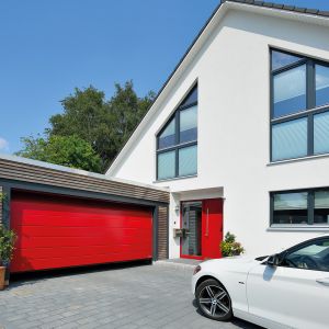 Ciekawą opcją mogą być również drzwi wejściowe w niecodziennym kolorze, np. czerwonym, które będą wizytówką naszego domu. Fot. Hörmann