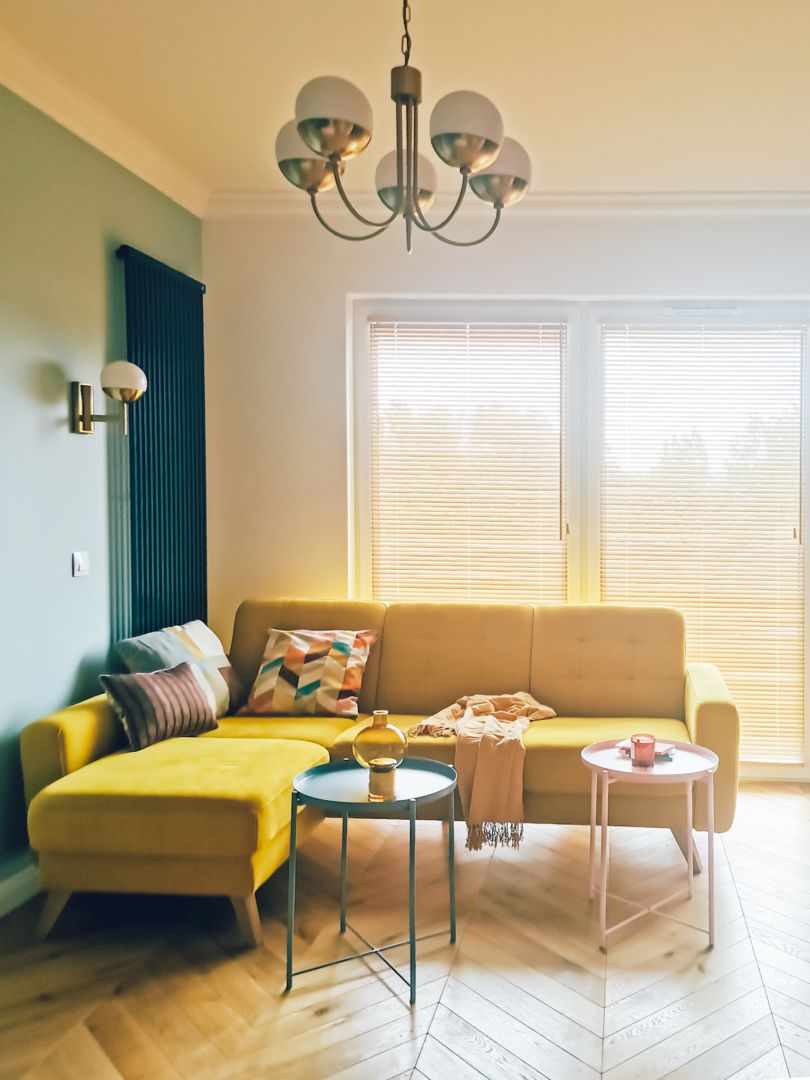 Najciekawszym elementem w salonie jest narożnik Elio marki Sweet Sit (Gala Collezione) w soczystym żółtym tapicerowaniu. Projekt: pracownia Bueno. Fot. Gala Collezione
