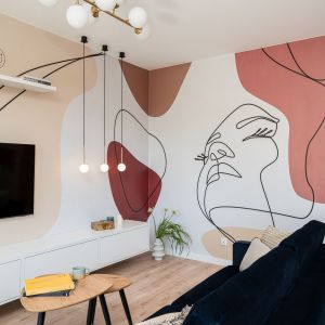 Ścianę w salonie zdobi tapeta z linearnym przedstawieniem twarzy – geometryczny, graficzny wzór. Projekt i zdjęcia: KODO Projekty i Realizacje Wnętrz