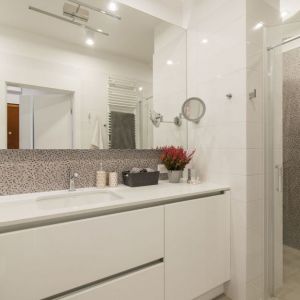 Mała, wygodna łazienka z prysznicem i z dużym lustrem.  Projekt i zdjęcie: KODO Projekty i Realizacje Wnętrz