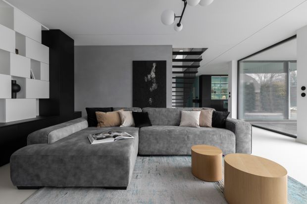 Dom o powierzchni 280 m² znajduje się w warszawskiej dzielnicy Wawer. Wnętrze utrzymane w stylu przytulnego minimalizmu idealnie spełnia potrzeby pięcioosobowej rodziny. Postawę aranżacji stanowi biel, która pięknie uzupełnia czerń, szarość