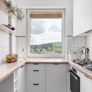 Mała kuchnia w bloku - biała z drewnem. Projekt wnętrza: Zuzanna Pikiel i Agata Piltz, pracownia Pikiel & Piltz. Fot. Jakub Nanowski - Perspektywa
