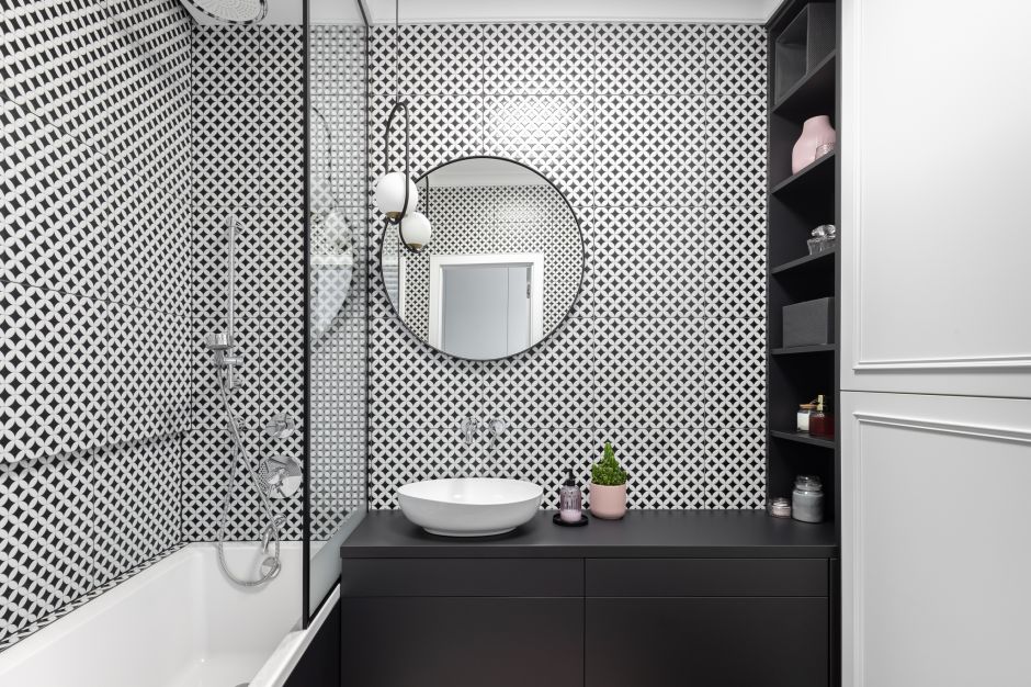 Mała łazienka z wanną. Piękne biało-czarne płytki i czarna szafka. Projekt: Daria Przewłócka. Fot. Natalia Kaczmarek Inkadr