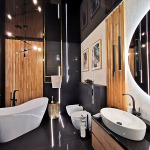 W łazience czerń przeplatana elementami drewna i złota. Projekt i zdjęcie: Agata Komar, Versalka Studio