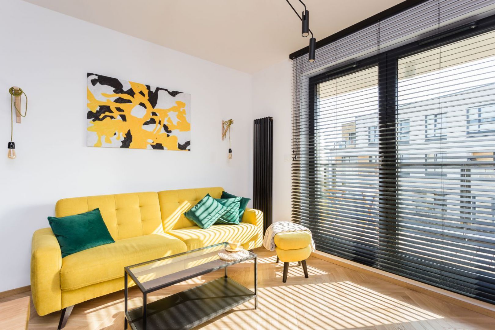 Żółta sofa w salonie, czarne meble w kuchni. Projekt wnętrza: Karolina Karwowska. Fot. Michał Młynarczyk