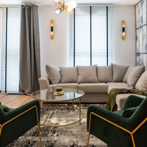 Zielone fotele w salonie, gres imitujący marmur w kuchni. Projekt wnętrza: DG Studio Donata Gadalska. Fot. Jacek Fabiszewski