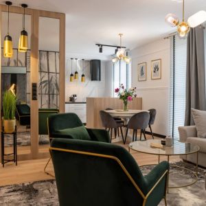Zielone fotele w salonie, gres imitujący marmur w kuchni. Projekt wnętrza: DG Studio Donata Gadalska. Fot. Jacek Fabiszewski