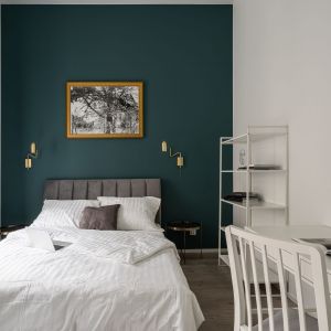 Sypialnia zaaranżowana w bieli i ciemnej zieleni. Projekt i zdjęcia: KODO Projekty i Realizacje Wnętrz
