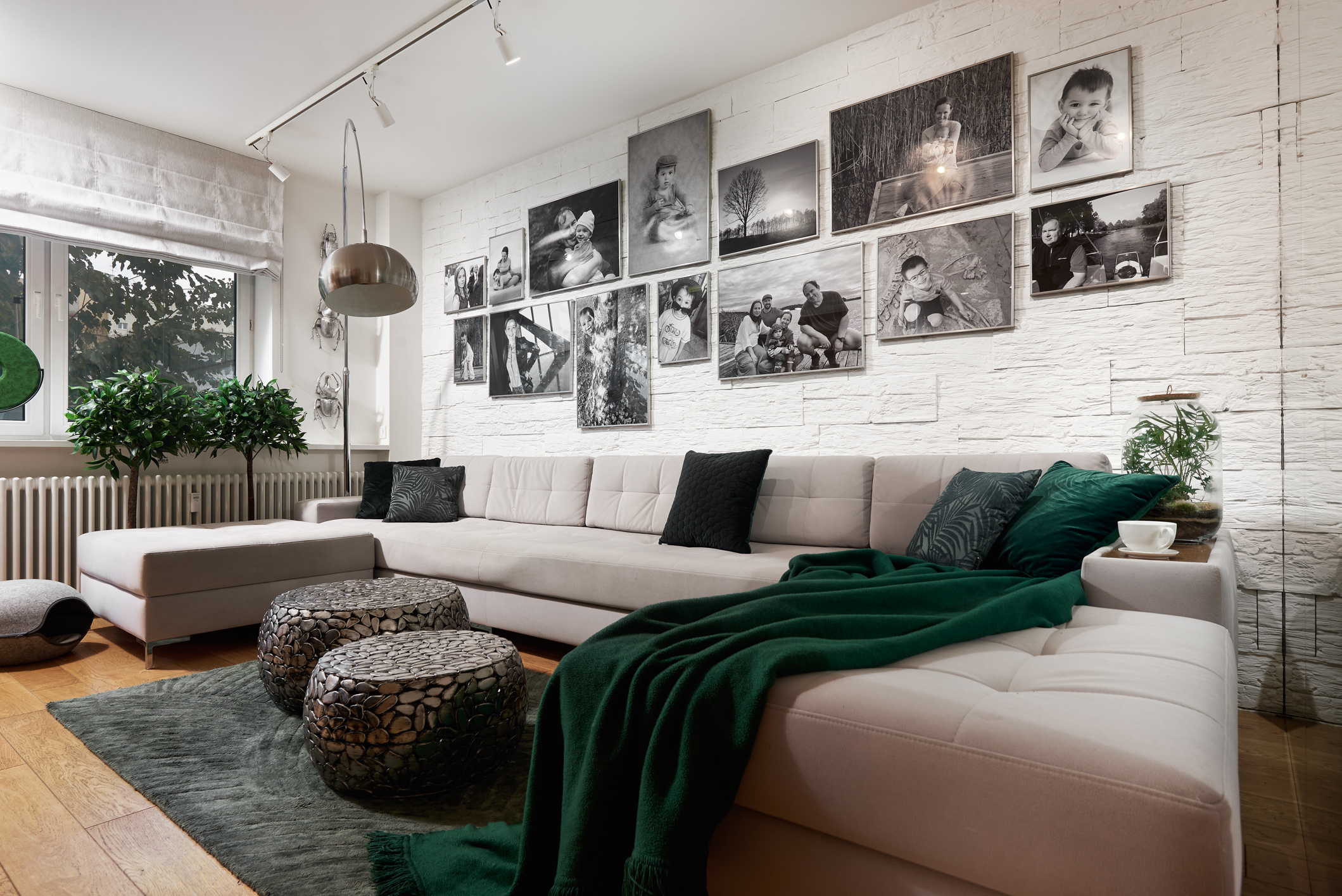 Ściana za sofą w salonie - kamienna okładzina i galeria rodzinnych zdjęć. Projekt Dariusz Grabowski, Dagar Studio. Fot. Marek Królikowski