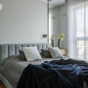 Tapicerowane łóżko w szarej sypialni. Projekt i zdjęcie: Maciej Balcerek, pracownia Perfect Space