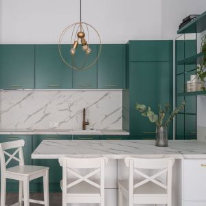 Zielone meble kuchenne są modne i wyglądają pięknie w połączeniu z płytkami z marmurowym wzorem. Projekt wnętrza i zdjęcie: KODO Projekty i Realizacje Wnętrz