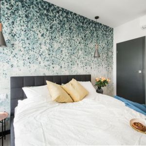 Tapeta z roślinnym wzorem na ścianie za łóżkiem w sypialni. Projekt wnętrza i zdjęcie: KODO Projekty i Realizacje Wnętrz