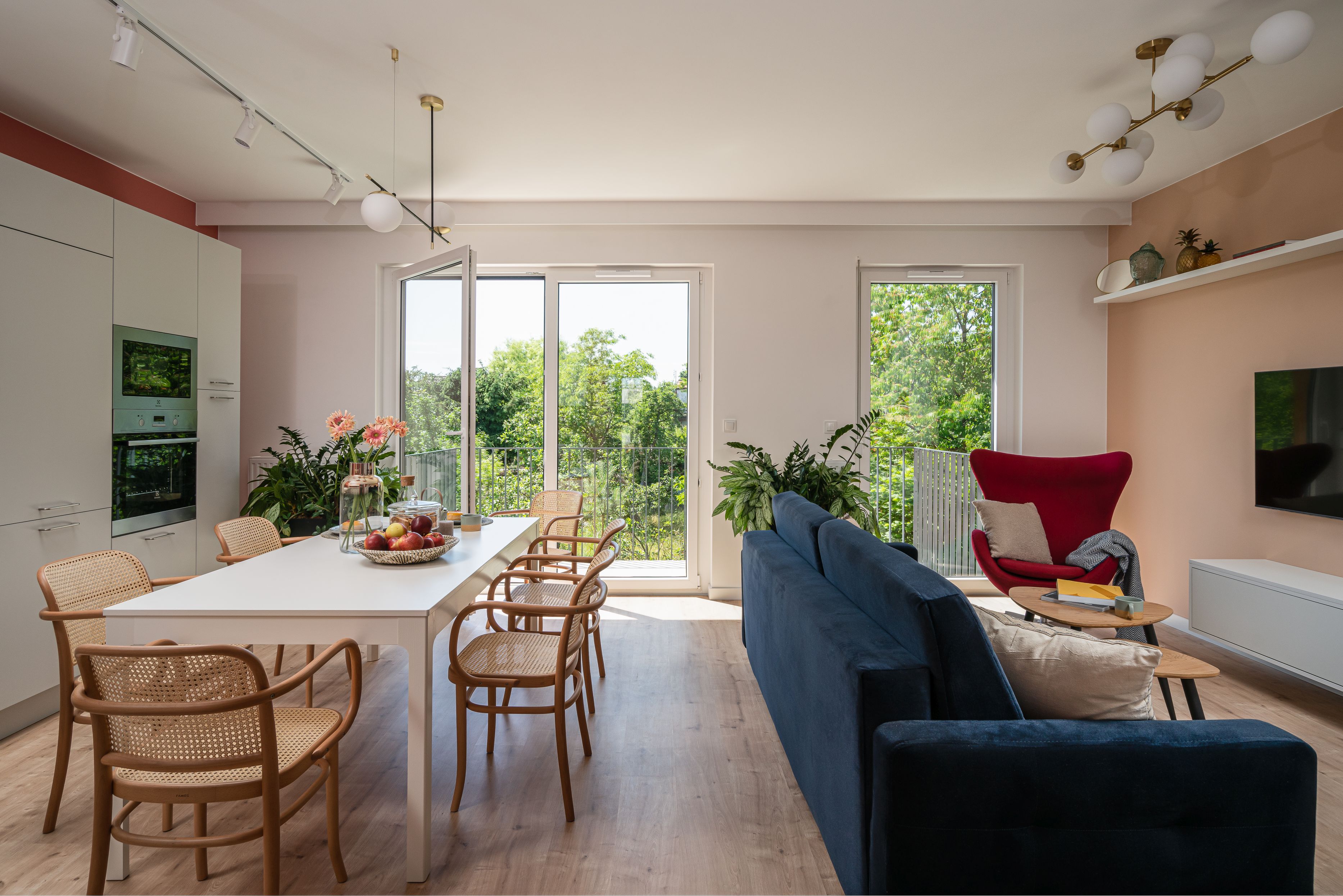 Granatowa sofa w salonie z kuchnią i jadalnią. Projekt i zdjęcia KODO Projekty i Realizacje Wnętrz