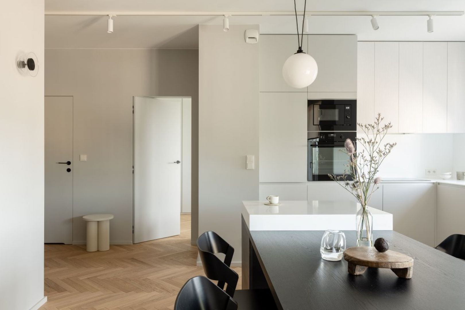 Kuchnia utrzymana jest w bielach i szarościach. Projekt wnętrza: 3XEL Architekci. Fot. PORA studio