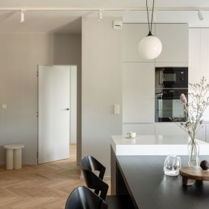 Kuchnia utrzymana jest w bielach i szarościach. Projekt wnętrza: 3XEL Architekci. Fot. PORA studio