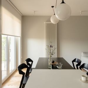 Centralnym punktem strefy dziennej jest wyspa z forniru w kolorze czarnego jesionu z dołączonym stołem i stylistycznie dopasowanymi krzesłami. Projekt wnętrza: 3XEL Architekci. Fot. PORA studio