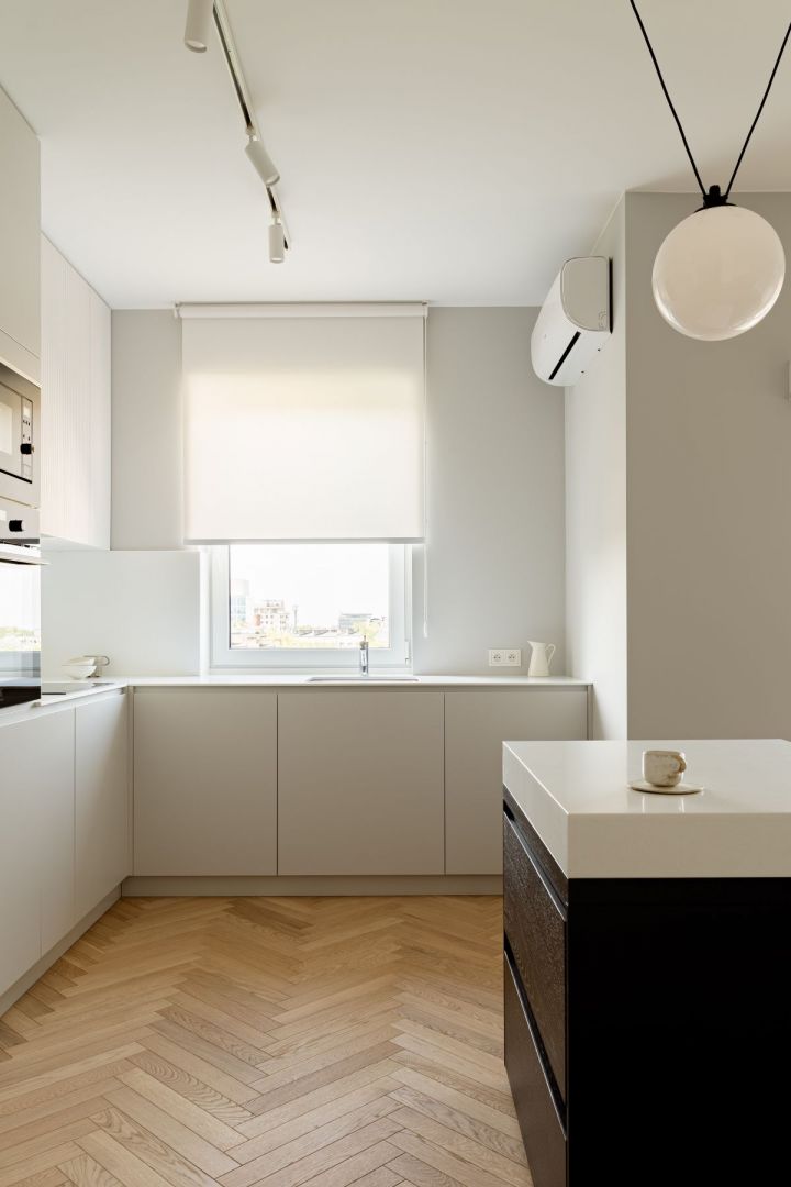 Minimalistyczny charakter kuchni podkreślają akrylowe blaty i ryflowane fronty wiszące. Projekt wnętrza: 3XEL Architekci. Fot. PORA studio
