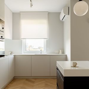 Minimalistyczny charakter kuchni podkreślają akrylowe blaty i ryflowane fronty wiszące. Projekt wnętrza: 3XEL Architekci. Fot. PORA studio