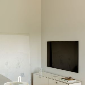 Biała szafka pod telewizor w salonie. Projekt wnętrza: 3XEL Architekci. Fot. PORA studio