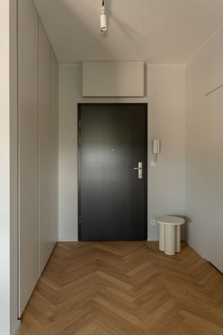 Po przekroczeniu progu mieszkania wchodzimy do jasnego przedpokoju z praktycznym stołkiem marki Noo.Ma. Projekt wnętrza: 3XEL Architekci. Fot. PORA studio