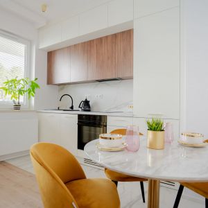 Biała kuchnia z drewnem w 38-metrowym mieszkaniu. Projekt i zdjęcia KODO Projekty i Realizacje Wnętrz
