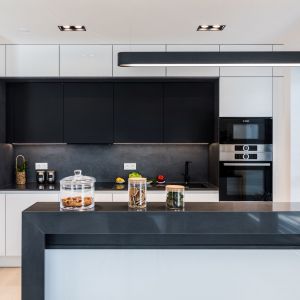 W kuchni króluje biel połączona z czernią. Projekt wnętrza i zdjęcia: KODO Projekty i Realizacje Wnętrz