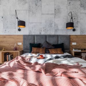 Ścianę za łóżkiem w sypialni zdobi tapeta imitująca beton. Projekt wnętrza i zdjęcia: KODO Projekty i Realizacje Wnętrz