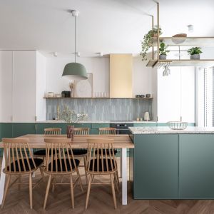 Salon z kuchnią i jadalnią. Pastelowe kolory i modernistyczny styl. Projekt Studio Loko. Fot. Jakub Henke @Kunioski