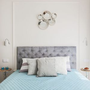Szary, pikowany zagłówek łóżka w jasnej, eleganckiej sypialni. Projekt i zdjęcie: KODO Projekty i Realizacje Wnętrz