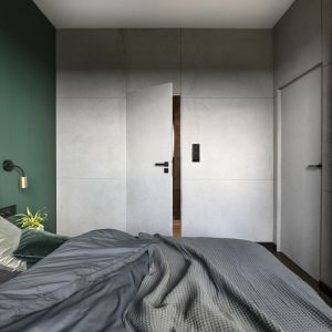 Część ścian w sypialni pokrywa szary beton, spójny z pozostałymi pomieszczeniami. Projekt wnętrza: Decoroom. Fot. Fotografka.pl