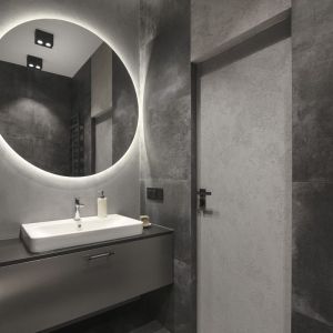Ściany i podłogi w łazience z wanną pokrywają płytki Keraben w odcieniu Priorat Grafito. Projekt wnętrza: Decoroom. Fot. Fotografka.pl