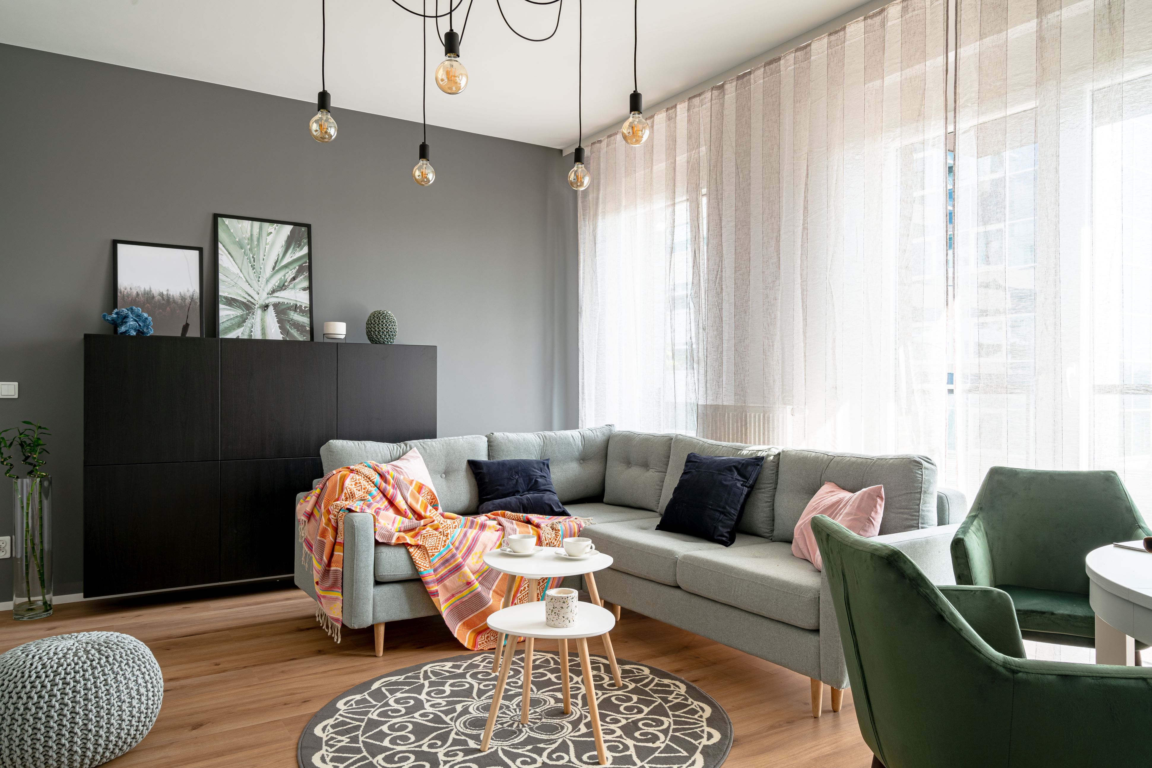 Elegancki i przytulny salon w bloku. Przejrzyste zasłony i okrągły dywan ze wzorem boho. Projekt wnętrza i zdjęcia KODO Projekty i Realizacje Wnętrz