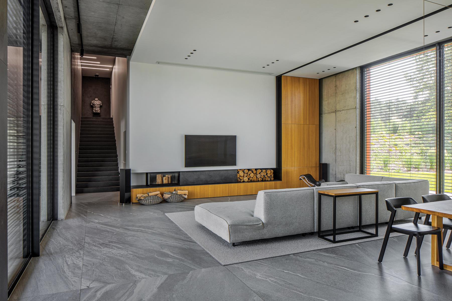 Wielkoformatowe szare płyty na podłodze i jasne ściany w loftowym salonie. Projekt wnętrza i zdjęcie: REFORM Architekt