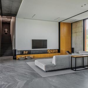 Wielkoformatowe szare płyty na podłodze i jasne ściany w loftowym salonie. Projekt wnętrza i zdjęcie: REFORM Architekt
