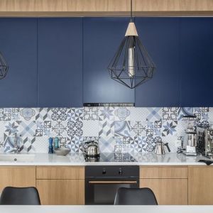Niebiesko-białe płytki na ścianie nad blatem w kuchni. Projekt wnętrza: pracowania Magma. Zdjęcia: Fotomohito