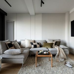 W salonie króluje stonowana szarość i naturalne materiały jak drewno. Projekt wnętrza: Hanna Pietras Architects. Zdjęcia i stylizacja: Folow the flow