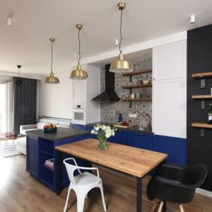 Szara kanapa i niebieskie meble w mały salonie z kuchnią. Projekt wnętrza: Anna Krzak. Zdjęcia: Bartosz Jarosz