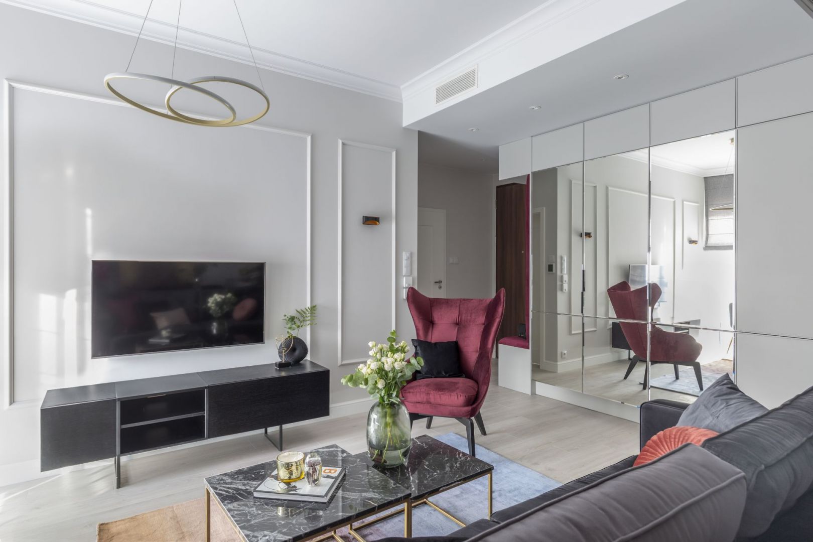 Elegancki salon w Warszawie. Bordowy fotel i dekoracje w kolorze Viva Magenta. Projekt i zdjęcia KODO Projekty i Realizacje Wnętrz