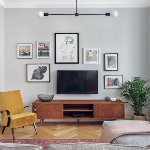 Telewizor powieszony na ścianie w salonie w klimacie vintage. Projekt wnętrza: pracownia Luumo. Fot. Tom Kurek